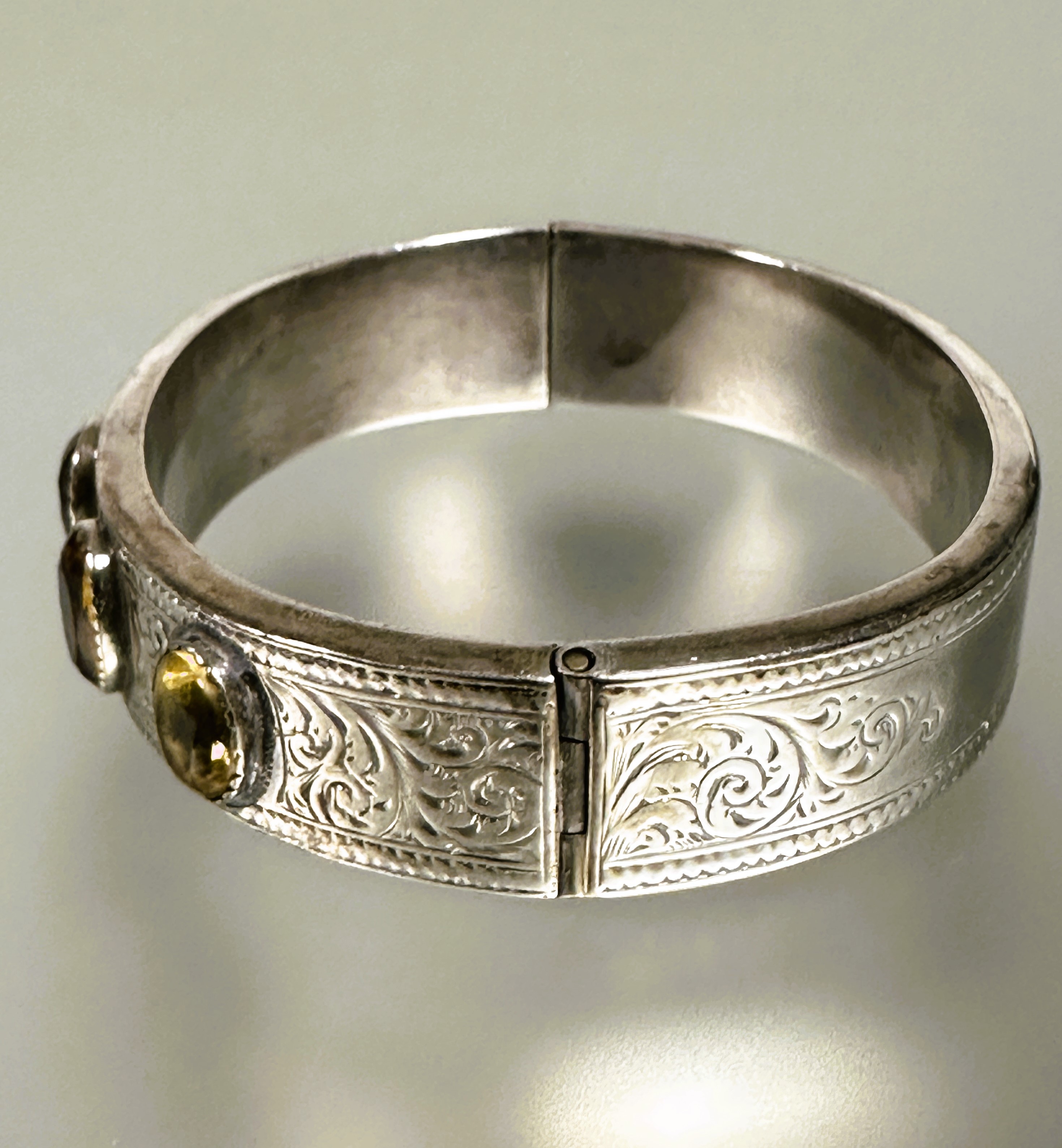 A late Victorian white metal engraved stiff hinged hollow bangle with five oval colette set - Image 4 of 5