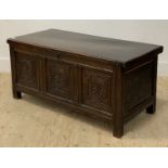 An 18th century oak coffer of pegged and jointed contruction, the hinged lid opening to an