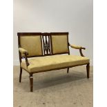 An Edwardian inlaid mahogany drawing room sofa, upholstered in golden damask, raised on square