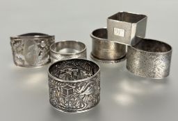 A collection of napkin rings to include a Birmingham silver with engine turned decoration and cast