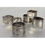 A collection of napkin rings to include a Birmingham silver with engine turned decoration and cast