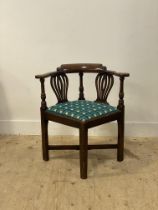 A George III elm corner chair, late 18th century, the shaped crest rail and out-swept arms on two