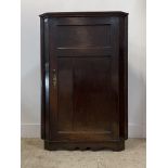 A George III oak corner cupboard, late 18th century, the twin panelled door enclosing three shelves,