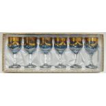 A boxed set of six blue and clear glass stemmed goblets/wine glasses, with gilt swag decoration (