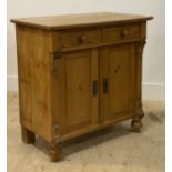 A small Victorian style pine side cabinet, with two drawers over two cupboard doors and flanked by