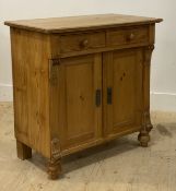 A small Victorian style pine side cabinet, with two drawers over two cupboard doors and flanked by