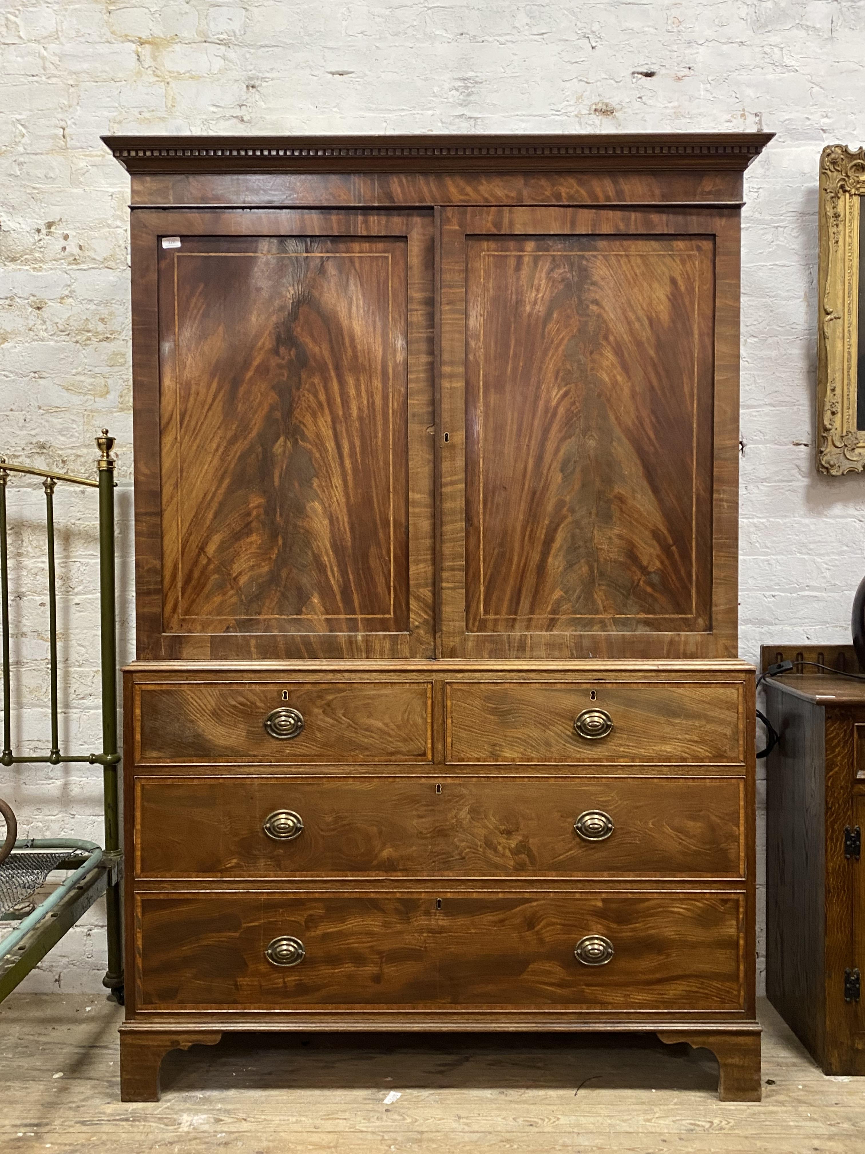 An early 19th century mahogany linen press, with dentil cornice above two fielded panelled doors