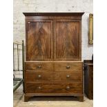 An early 19th century mahogany linen press, with dentil cornice above two fielded panelled doors