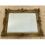 A 19th century and later gilt composition framed wall mirror. 90cm x 73cm.