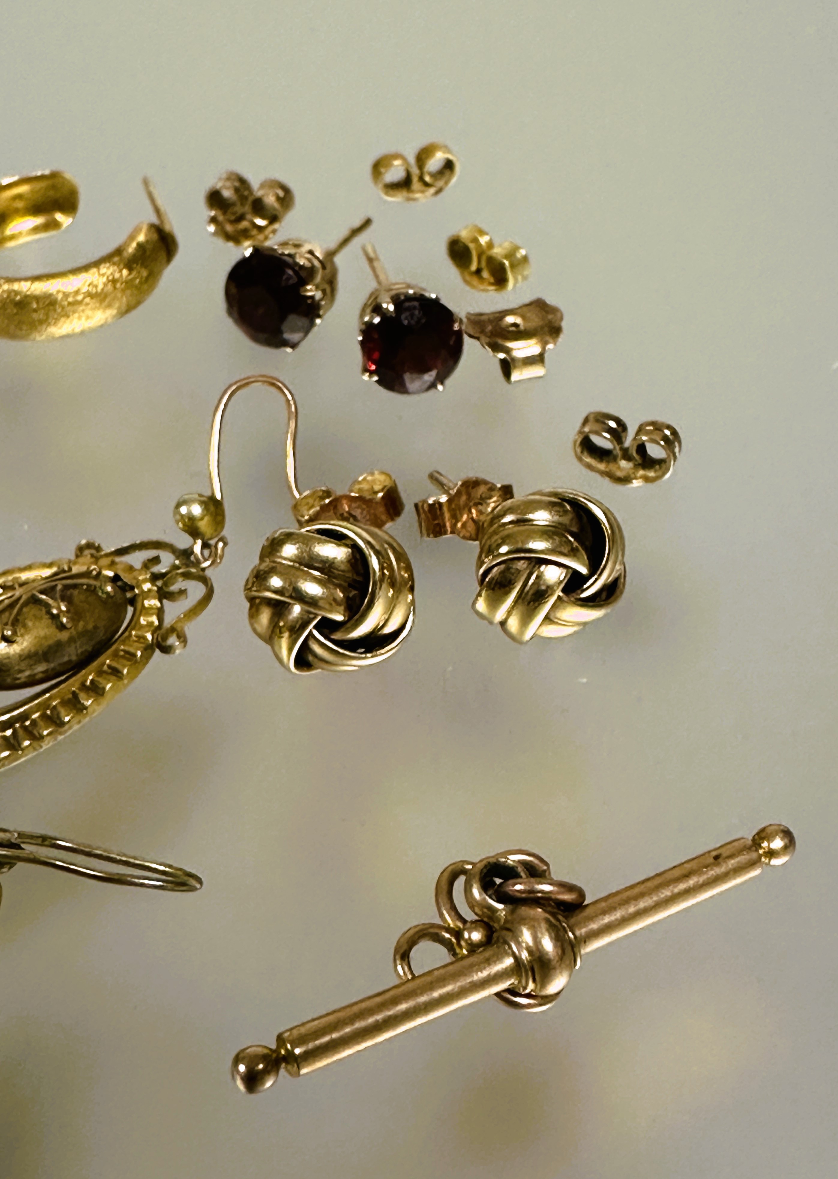 A collection of earrings to include a pair of 9ct gold garnet stud earrings, a pair of 9ct gold knot - Image 3 of 5