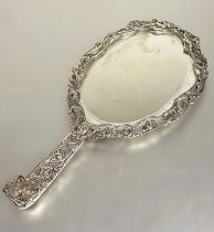 A Victorian London silver hand mirror with cast engraved scrolling border decorated with birds,