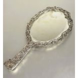 A Victorian London silver hand mirror with cast engraved scrolling border decorated with birds,