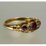 A 18ct gold three stony ruby ring the center cut stone 0.15ct flanked by a rose cut diamond and