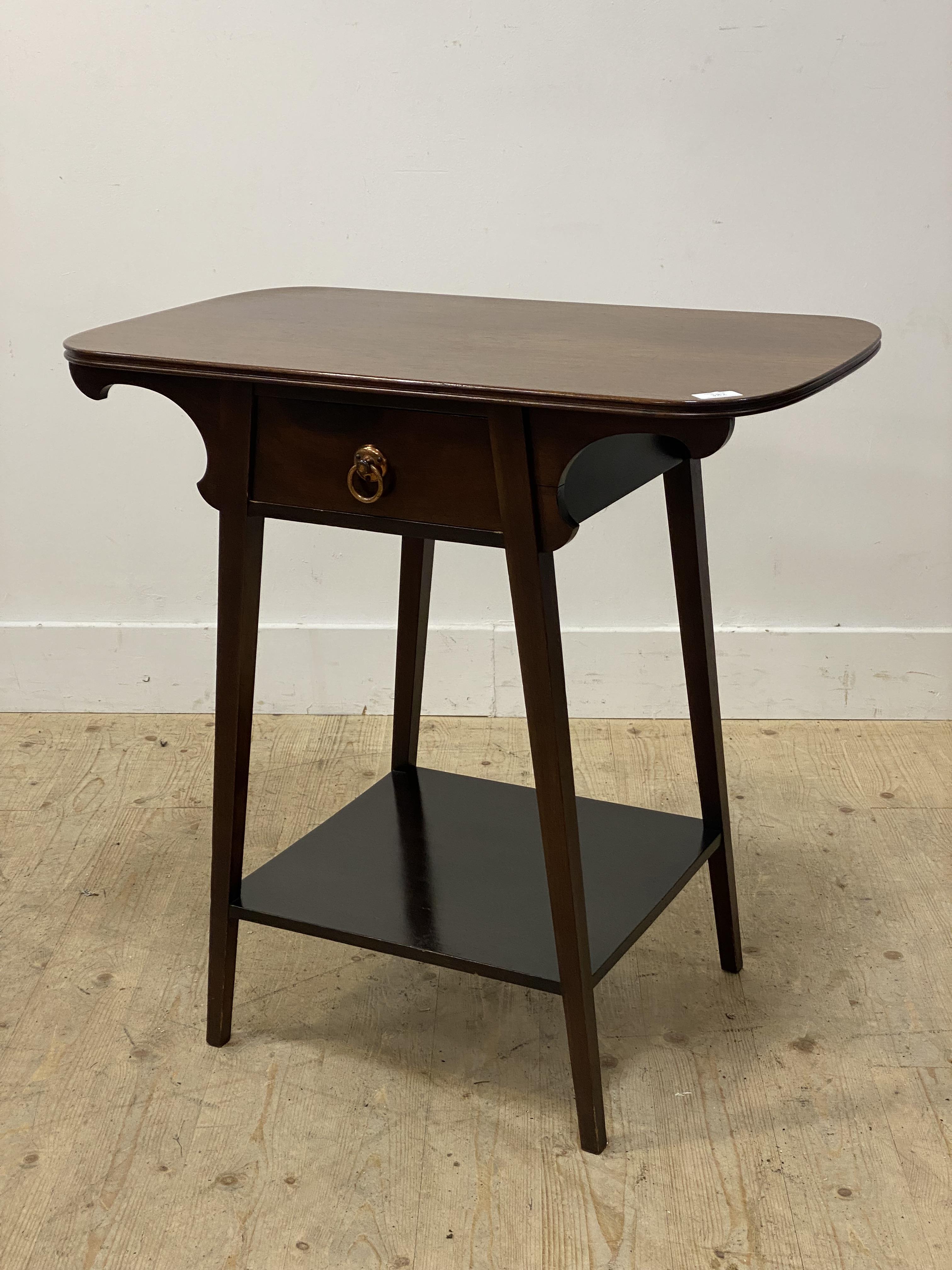 An Arts and Crafts period mahogany side table, the shaped top above a drawer and raised on square