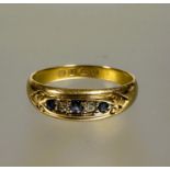 A Edwardian 18ct gold graduated three stone sapphire ring,  the central stone 0.07ct flanked by a