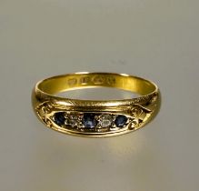A Edwardian 18ct gold graduated three stone sapphire ring,  the central stone 0.07ct flanked by a