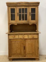 A Dutch pine two part dresser, the top section with bowed centre and four glazed doors, above a