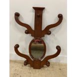 A Victorian mahogany wall mounted hat and coat stand with twin scrolling arms to each side and