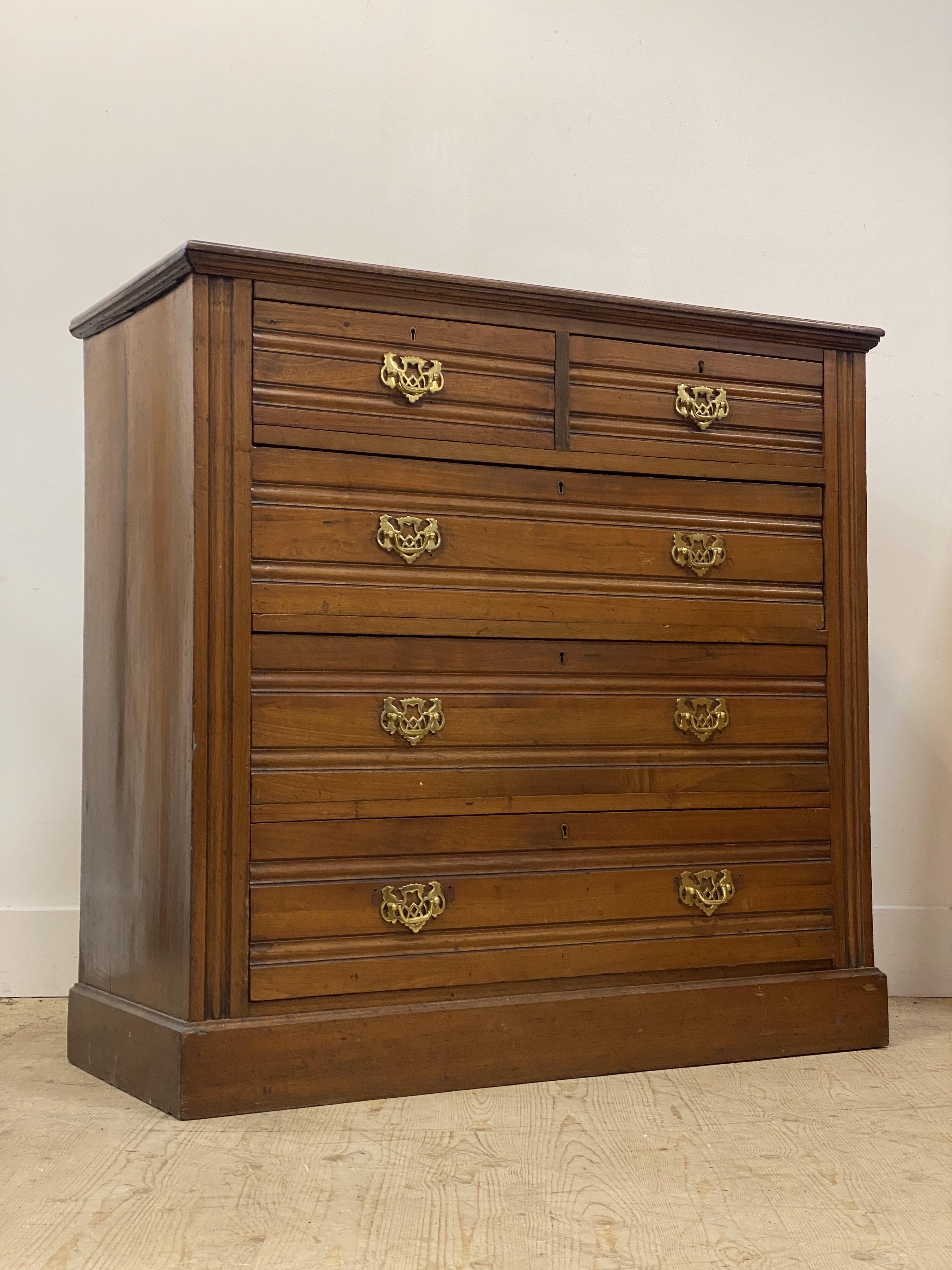 An Edwardian walnut chest, fitted with two short and three long drawers, raised on a plinth base.