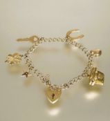 A 9ct gold kerblink bracelet with heart shaped padlock and safety chain and six various charms to