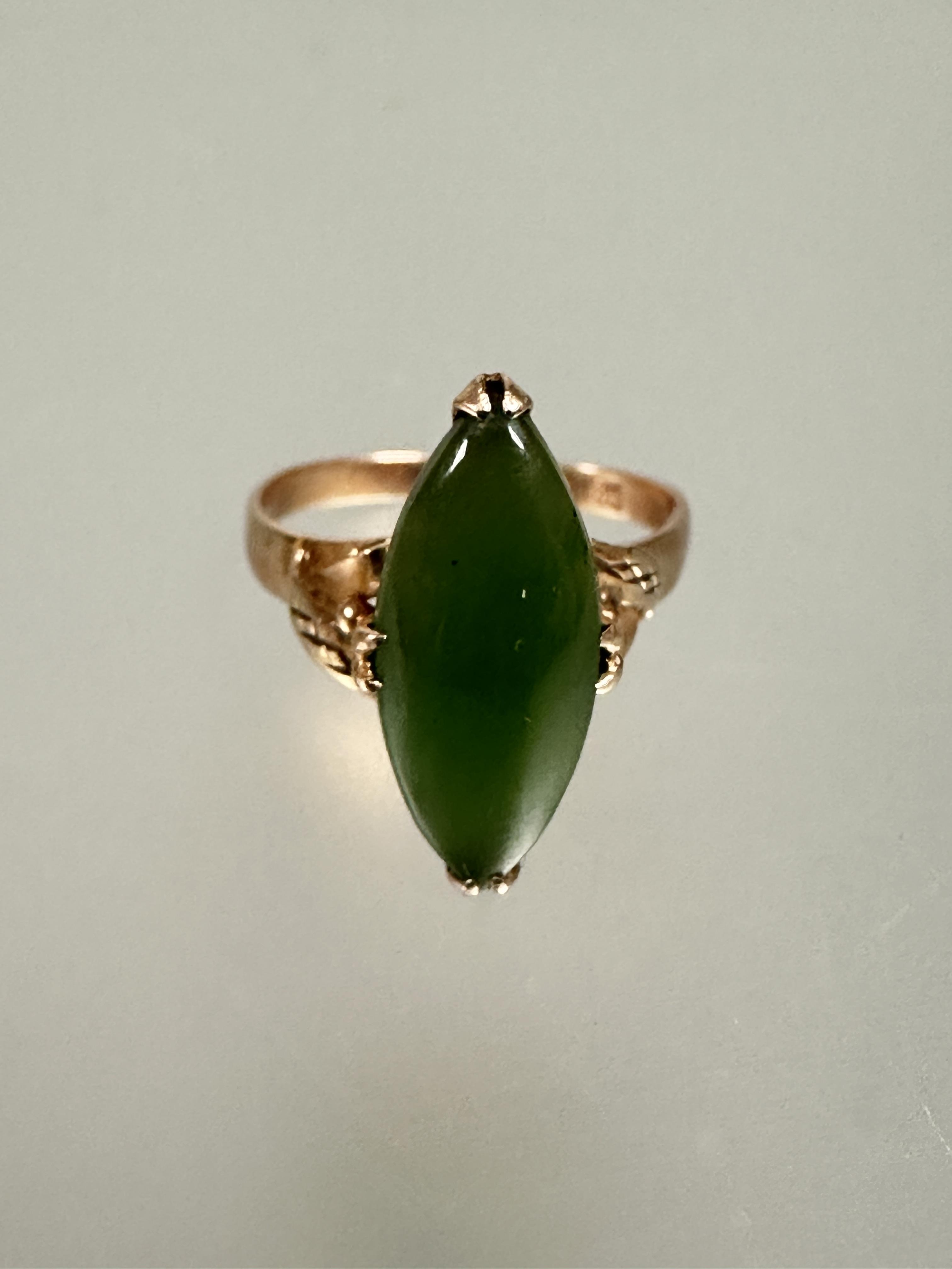 A 18ct gold ring set navette green stone mounted in four claw setting with scrolling leaf