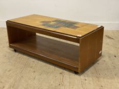 A mid century teak veneered two tier coffee table, the top inset with orange glazed tiles having