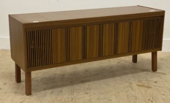 A mid century teak veneered radiogram cabinet, with hinged lid opening to a void interior, raised on