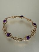 A 9ct gold knot and circular panel link chain bracelet set five circular faceted amethysts, each