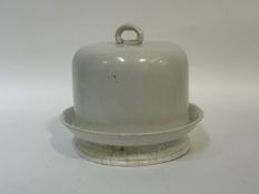 A white ceramic cake stand and domed cover with ring handle to top. (h-28cm w-30) (signs of age