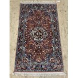 A Persian style silk and cotton blend rug, the central field profusely decorated with arabesques,
