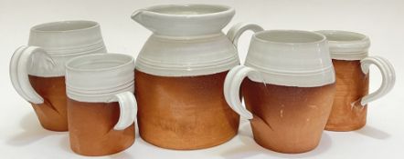 Simon Pearce, a group of earthenware studio pottery with white glaze comprising four mugs of various