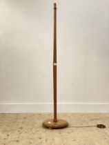 A mid century turned teak lamp standard, the stop fluted post on a circular base with compressed bun