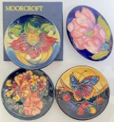 Three Moorcroft tube lined pin dishes, variously decorated with floral designs and a butterfly (