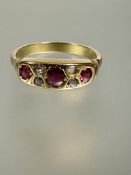 An 19thc yellow metal ring set three graduated rubies, the centre stone approximately 0.03ct flanked