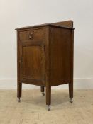 An early 20th century oak bedside chest, fitted with a drawer above a cupboard, raised on stile
