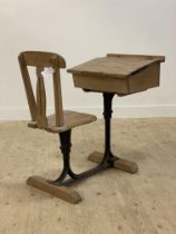 A late 19th century pine school desk, the double hinged writing slant above a storage well and seat,