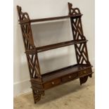 A reproduction mahogany wall rack in the Chippendale taste, with lattice pierce carved panel end