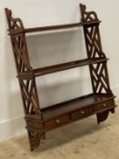 A reproduction mahogany wall rack in the Chippendale taste, with lattice pierce carved panel end
