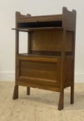 An early 20th century oak reading shelf, with book trough above a writing slide, open shelf and