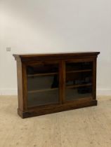 A Victorian rosewood bookcase, the projecting top above two glazed doors enclosing an interior