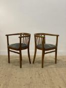 A Vintage pair of varnished hardwood desk tub chairs, with sprung and upholstered drop in seat pads,