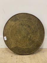 An eastern hammered brass circular table top. D46cm.