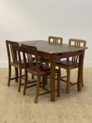 A 1940's teak and mahogany extending dining table, the panelled top opening to a leaf, raised on