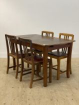 A 1940's teak and mahogany extending dining table, the panelled top opening to a leaf, raised on