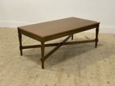 A reproduction oak coffee table, the rectangular top raised on turned and fluted supports united