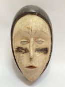 A Gabonese carved wood African mask (h- 35cm, w- 23cm)