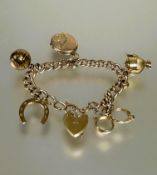 A 9ct gold hollow kerb link six charm bracelet with heart shaped padlock and safety chain (a/f),