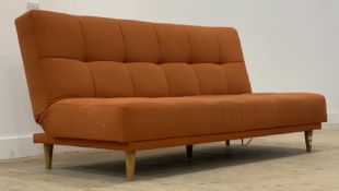 John Lewis, a contemporary sofa bed, upholstered in orange buttoned fabric and raised on turned