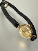 A Geneve 9ct gold ladys quartz oval wristwatch with baton hour markers on black leather strap L 1.
