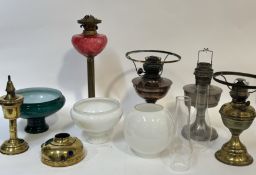 A collection of various oil lamp bases comprising, one tall brass Corinthian style with cranberry